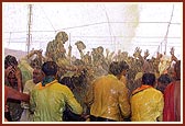 Swamishri drenches the joyous devotees in a shower of holy, colored water
