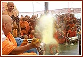 Swamishri happily directs a water spray on the sadhus