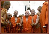 Swamishri is seen drenched in colored water while leaving the festival ground