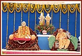 Swamishri on stage besides the animatronic murti of Yogiji Maharaj