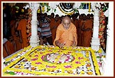 Swamishri reverentially offers flowers at the shrine of Yogiji Maharaj in the Yogi Smruti Mandir 