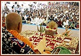 Performs morning puja while sadhus sing bhajans in praise of Yogiji Maharaj