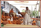 A youth being initiated into the parshad-fold. First he receives a new kanthi from a senior sadhu...