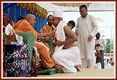 ... and finally Swamishri smears chandan on his forehead, chest and arms and gives him the diksha-mantra