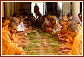 Sadhus and parshads cutting vegetables