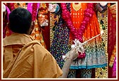 After decorating the deities a sadhu performs arti