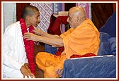 A kishore from the USA welcomes Swamishri with a garland