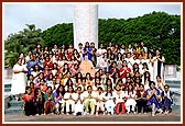 A group photo of the kishoris with Shri Harikrishna Maharaj and a photographic murti of Swamishri