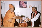 Pujya Balmukund Swami presents a memento to the Governor