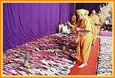 Swamishri showers sanctified flower petals on the account books 