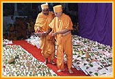 Swamishri showers sanctified flower petals on the account books 