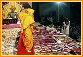 Swamishri showers sanctified flower petals on the account books 