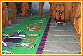 Swamishri enters the Smruti Mandir and observes the rangoli done by a yuvak
