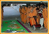 Swamishri enters the Smruti Mandir and observes the rangoli done by a yuvak