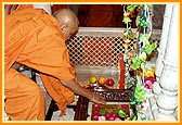 Swamishri reverentially touches the holy charnarvind of Shriji Maharaj in Akshar Deri
