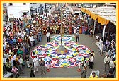 Swamishri looks at the colorful and artistic rangoli done by devotees before the mandir steps 