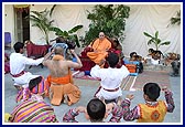 Outside the mandir, Swamishri sits while a welcome dance is performed