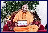 During thal dance Swamishri sits holding Thakorji