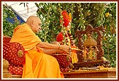 Swamishri sprinkles colored water on Shri Harikrishna Maharaj 