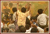 Devotees and sadhus euphorically raise their hands as they are blessed with fragrant holy water