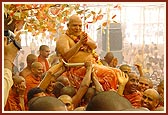 Sadhus enjoy the divine experience of being drenched with the holy water sprayed by Swamishri