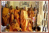 Swamishri performing shangar arti of Thakorji who is adorned for the Rangotsav celebration, at the Shri Swaminarayan Mandir, Sarangpur