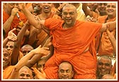 Sadhus enjoy the divine experience of being drenched with the holy water sprayed by Swamishri