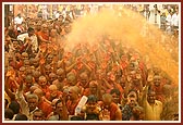 Devotees and sadhus euphorically raise their hands as they are blessed with fragrant holy water