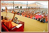 Swamishri and the parshads and sadhaks raise the new janois during the initiation ceremony