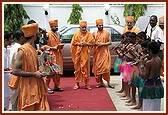 Swamishri is welcomed by satsangi balaks in traditional African dress