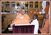 A young Kenyan balak receives blessing from Swamishri after reciting Swami ni Vato