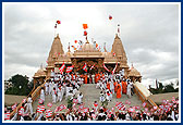 Swamishri and devotees waves the BAPS flag in honor of the BAPS centenary celebrations