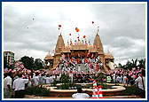 Swamishri and devotees waves the BAPS flag in honor of the BAPS centenary celebrations