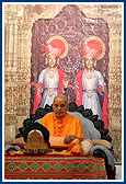 Swamishri's morning puja with a backdrop of murtis and three shrines of Bochasan Mandir 