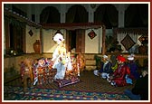 Shriji Maharaj seated with devotees