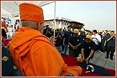 Swamishri joyfully bowing to the devotees as they file past to begin the Walk