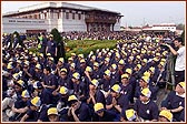 Devotees seated in special T-shirts and caps eagerly awaiting the start of the Walk