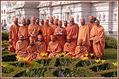 Swamishri and sadhus in the garden next to the Mandir