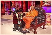 Swamishri garlands two young schoolchildren