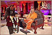 Swamishri garlands two young schoolchildren