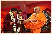 Swamishri garlands two young schoolchildren