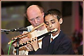 A student charms the devotees with his flute playing