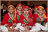 Students dressed in colourful costumes await Swamishri's arrival