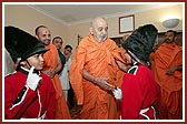 Swamishri blessing two balaks dressed as London guards