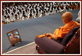 Swamishri watching a video presentation of Harikrishna Maharaj's day