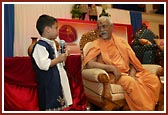 A balak poses a question to Pujya Doctor Swami
