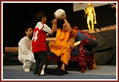 Swamishri plays with a balak at the launch of the Pramukh Cup