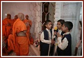 Balaks singing a prarthana as Swamishri performs darshan in the Mandir