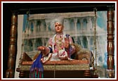 Bhagwan Swaminarayan seated on a wooden hindolo