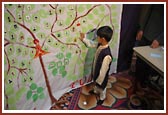 A young Balak adds his own photo to the tree after the Tulsi-Tula of Harikrishna Maharaj